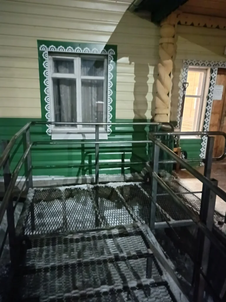 Металлический пандус с перилами у дома